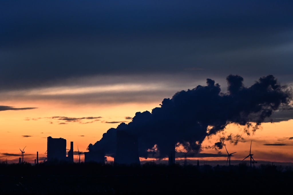 Die Sonne ist hinter einem Braunkohlekraftwerk untergegangen.