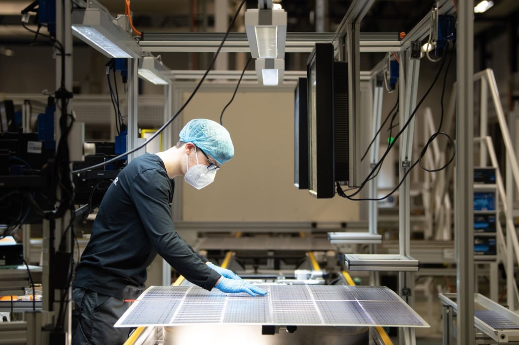 Ein Mitarbeiter steht bei der Qualitätskontrolle an einer Produktionslinie für Solarmodule.