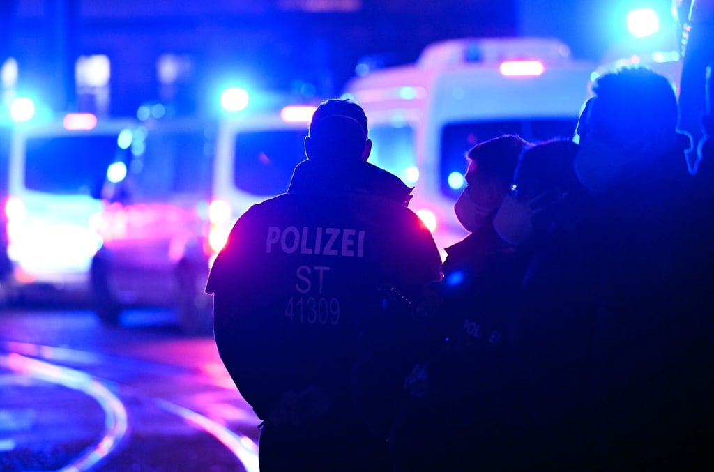 Polizisten stehen bei einem Einsatz auf der Straße.