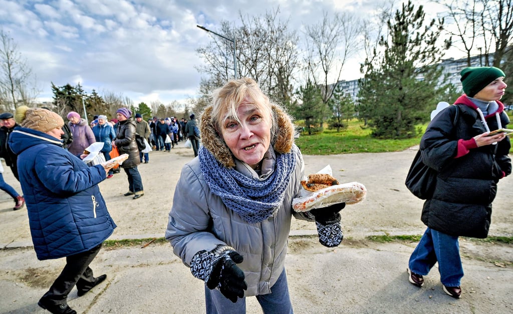 Eine Frau hält in Saporischschja eine kostenlose Pizza in der Hand, gebacken von ausländischen Freiwilligen für Menschen, die durch den Krieg Russlands gegen die Ukraine vertrieben wurden. Die Magdeburger Partnerstadt benötigt Spenden, um die vielen Herausforderungen zu bewältigen.
