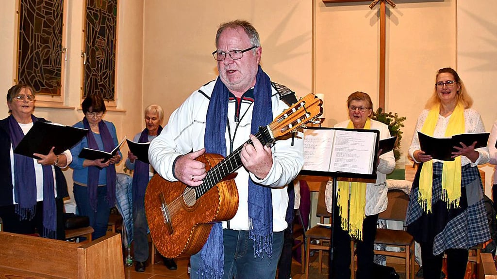 Chorleiter Olaf Johanson spielt auf seiner Gitarre, begleitet den Haldensleber Eine-Welt-Chor, dirigiert und singt auch als Solist.