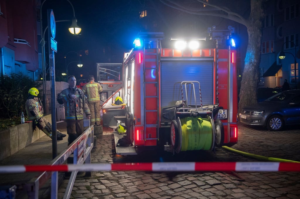 Einsatzfahrzeuge der Feuerwehr stehen in der Silvesternacht unweit der Urbanstraße.