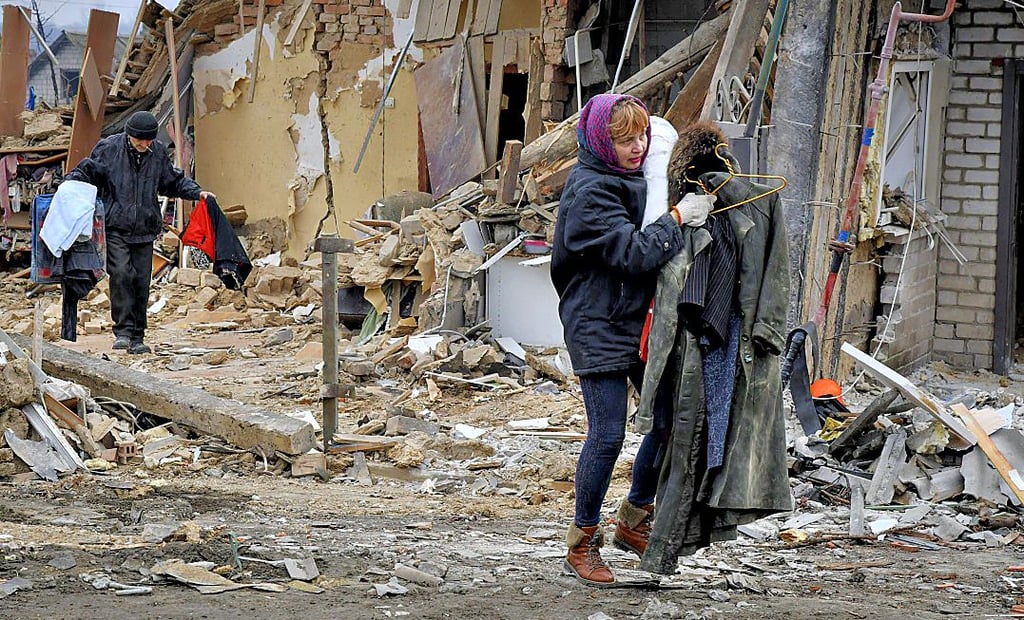 Anwohner tragen in der Magdeburger Partnerstadt Saporischschja in der Ukraine am Neujahrstag ihre Habseligkeiten aus den Trümmern ihres Haues, das nach ukrainischen Angaben bei einem russischen Raketenangriff zerstört wurde.