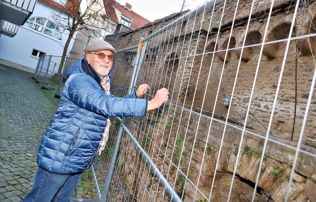 Stadtführer Helmut Schakel an dem noch mit Bauzäunen abgesperrten Mauerstück. Es soll nun saniert werden.