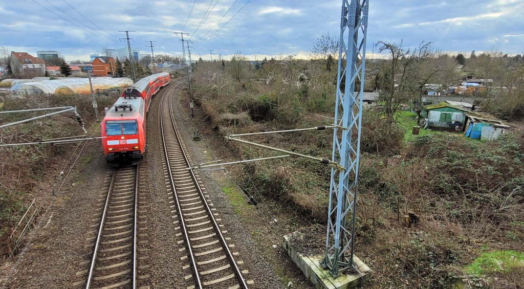 Wohnbebauung (links) und Kleingärten (rechts) säumen die Bahnstrecke von Stendal nach Magdeburg.