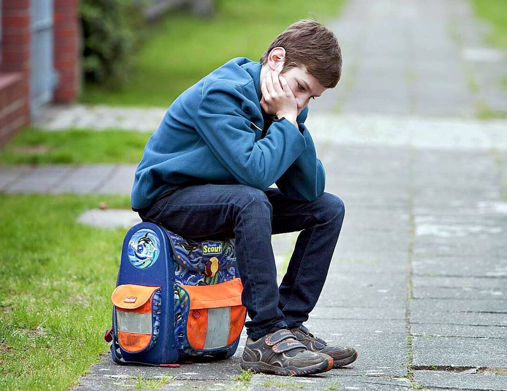 Ein deprimierter Schüler sitzt auf seinem Ranzen: Durch die langen Schulschließungen in der Corona-Pandemie haben viele Schulkinder massive Rückstände beim Lernstoff hinnehmen müssen.