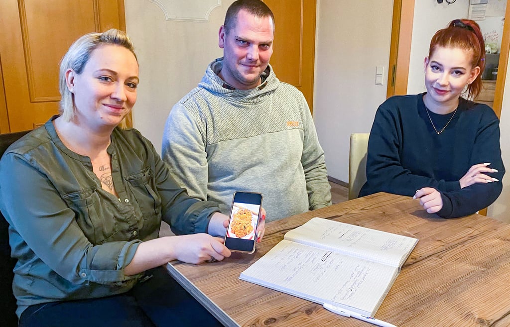 Kati und Tobias Sauer übernehmen die bisherige „Manufaktur am Wald“ in Annaburg, hier mit Vanessa Seidel, die für den Medienauftritt sorgt. Das Foto, das Kati Sauer auf dem Handy präsentiert, zeigt eine Platte, wie sie die Familie bei Veranstaltungen selbst anfertigen wird.