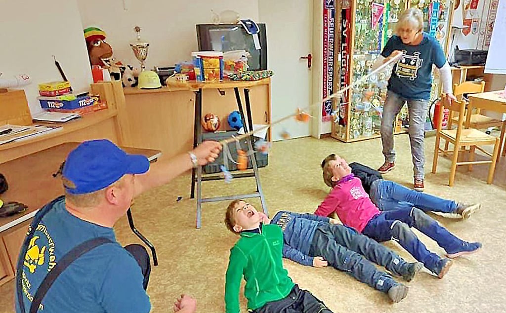 Bei der Kinderfeuerwehr wurde mit lustigen Spielen gefeiert. Hier dürfen Kinder nach Süßigkeiten an einer Leine schnappen, die Steffen und Ingelore Alex halten.