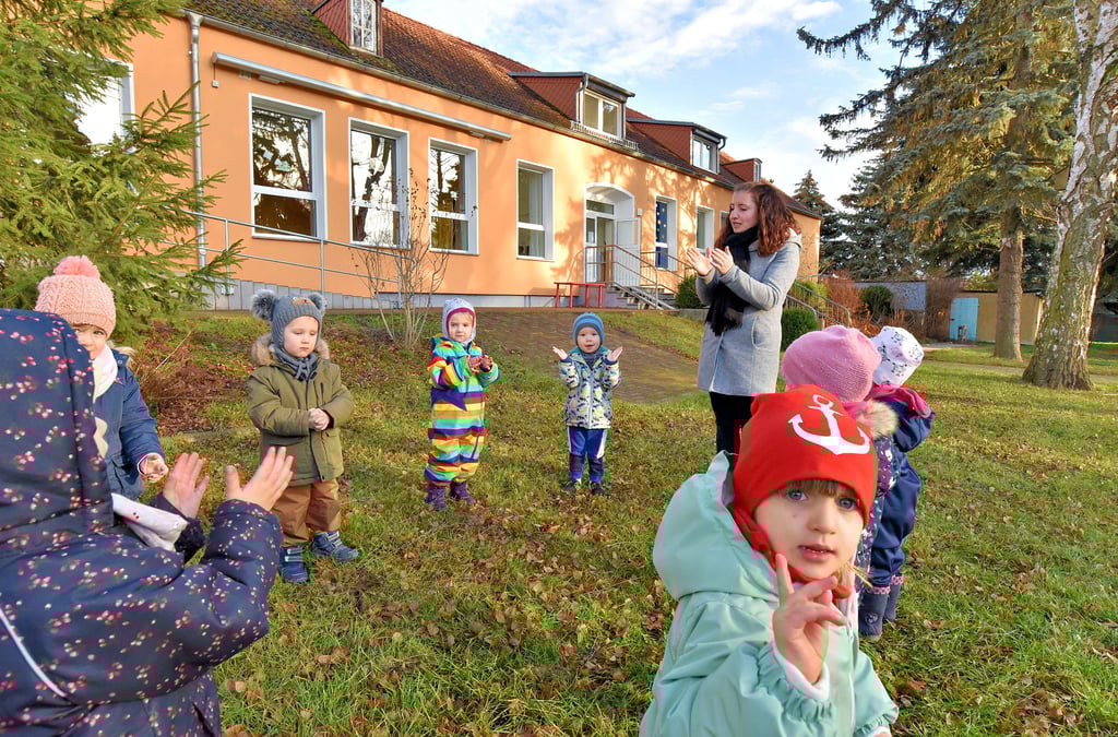 Die Kinder der Kita „Käthe Kollwitz“ in Granschütz beim Spielen mit Erzieherin Susan Lampert – im Hintergrund ist das Kita-Gebäude zu sehen, das in diesem Jahr für rund zwei Millionen Euro ausgebaut werden soll.