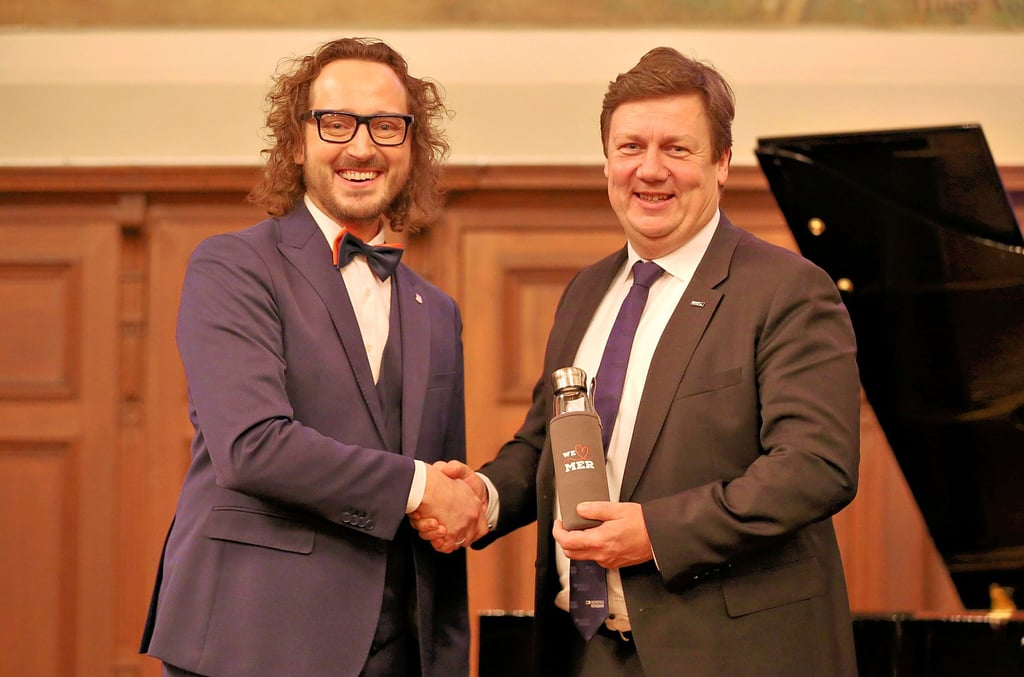 OB Sebastian Müller-Bahr überreicht Hochschulrektor Markus Krabbes eine Mersburg-Flasche.