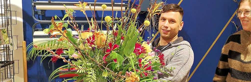 Florist Sadat Said Farin mit einem beeindruckenden Blumengesteck neben seiner Chefin Christine Heuer.