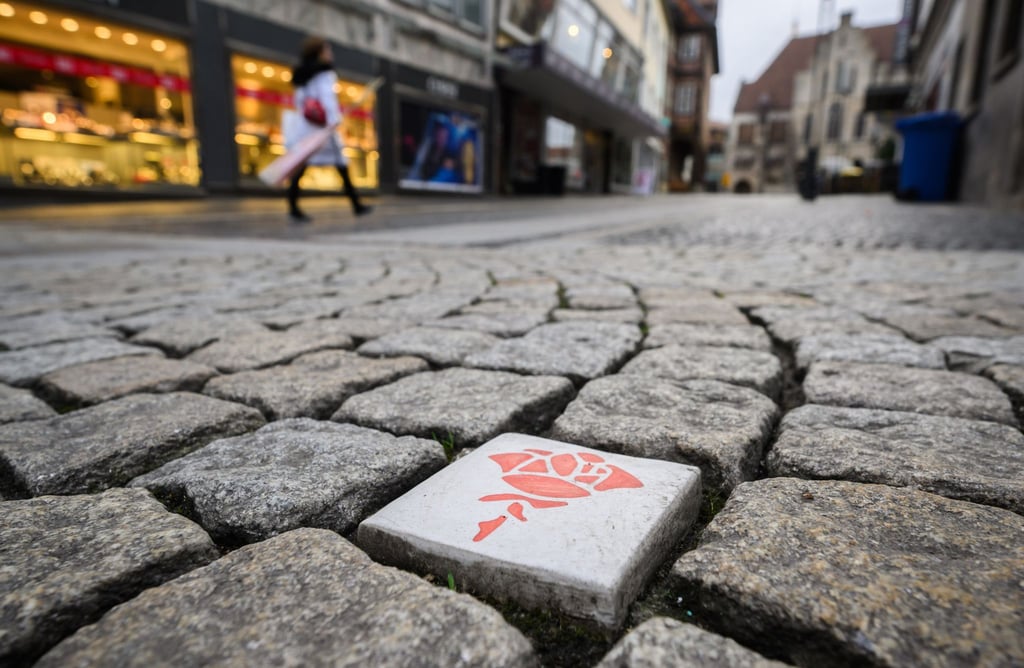 Mit über 150 in den Boden eingelassene Keramik-Rosen wird in Hildesheim ein Rundgang durch die Stadt markiert.