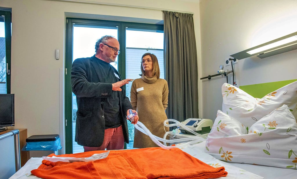 Nadine Rusetzki und Johannes Koschig an einem Pflegebett mit Beatmungstechnik.