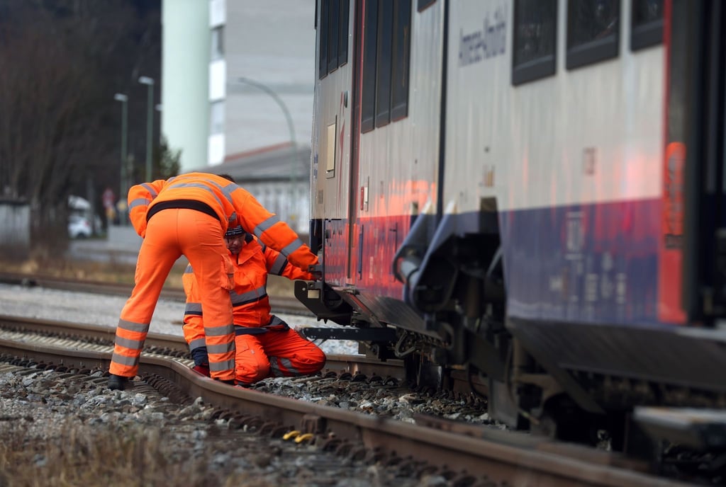 Bahnmitarbeiter begutachten den entgleisten Zug der Bayerischen Regiobahn.