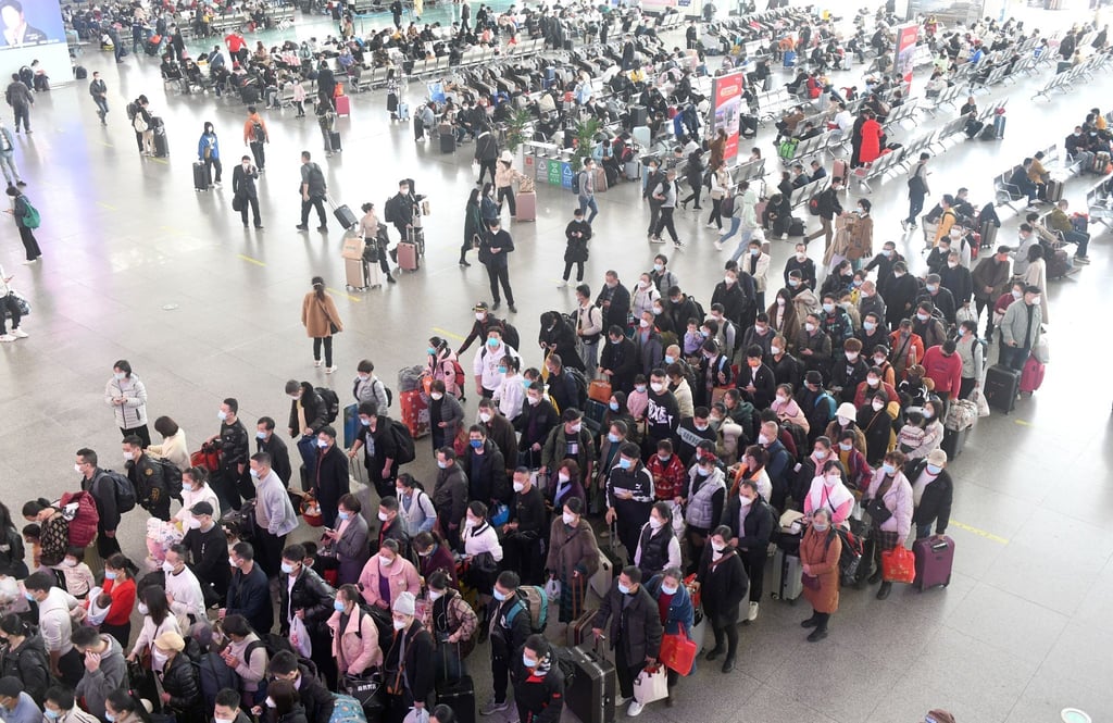 Zahlreiche Fahrgäste stehen in einem Bahnhof in der südchinesischen Provinz Guangdong Schlange.