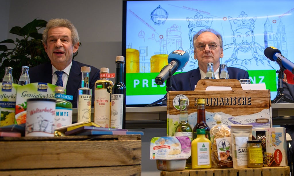Regierungssprecher Matthias Schuppe (l) und Reiner Haseloff (CDU), Ministerpräsident des Landes Sachsen-Anhalt, sitzen bei der Pressekonferenz zur Teilnahme Sachsen-Anhalts an der Internationalen Grünen Woche hinter Produkten des Bundeslandes.