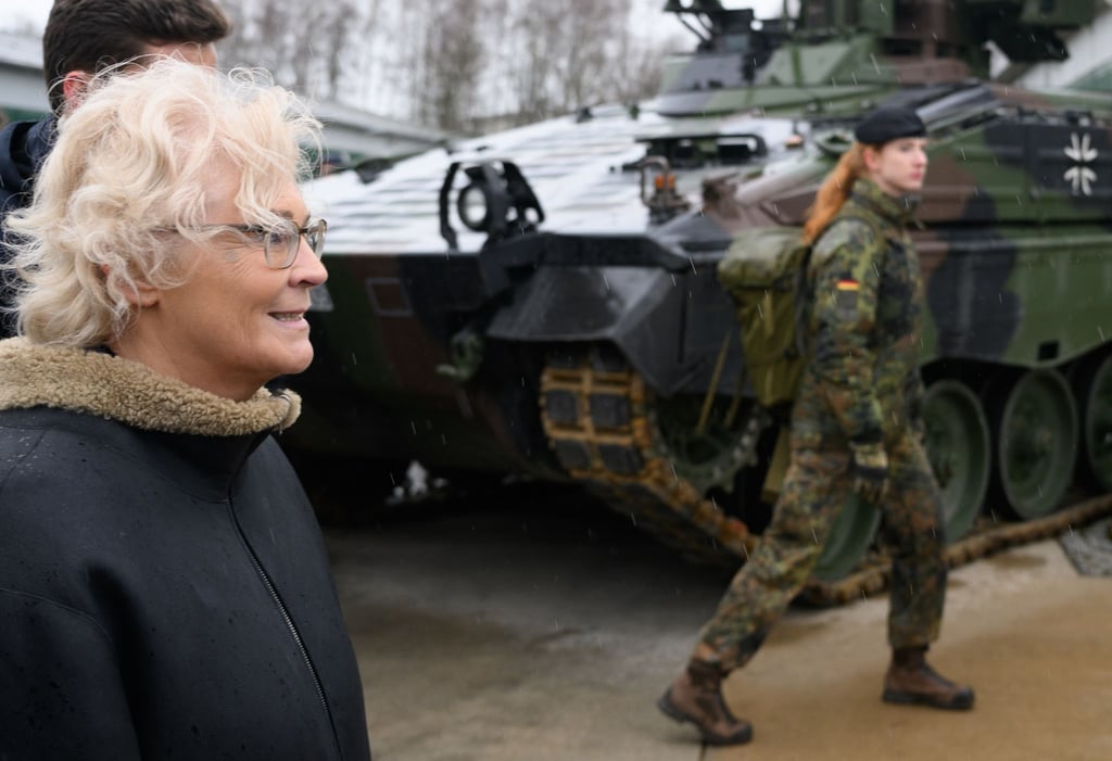 Bundesverteidigungsministerin Christine Lambrecht (l) geht bei ihrem Besuch an einem Schützenpanzer Marder vorbei.