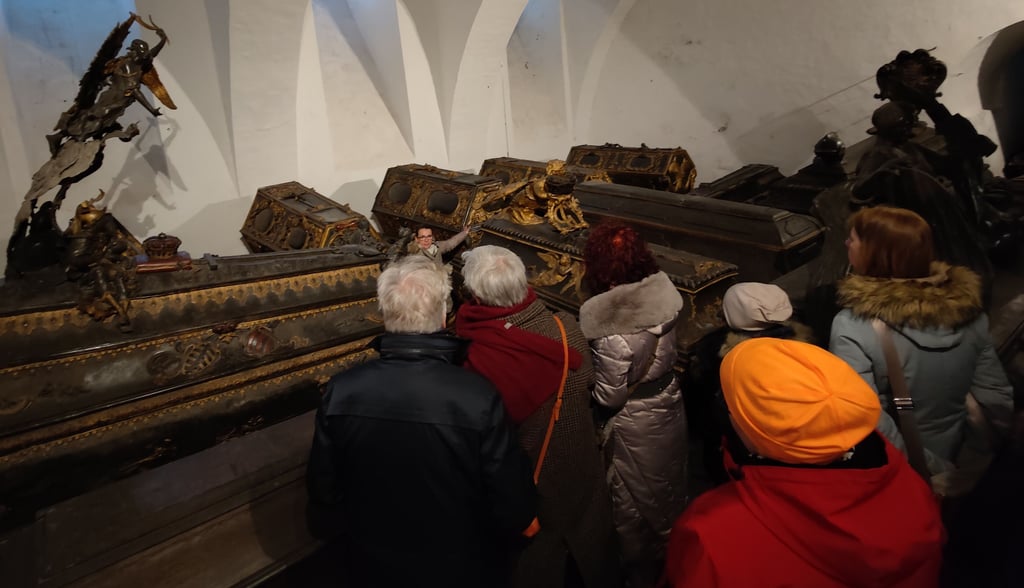 Museumsleiterin Bianca Bernstein (hinten) erklärt den Besuchern i der beengten Fürstengruft unter der Schlosskirche von Weißenfels, was es mit den Särgen der Herzöge und ihrer Familien auf sich hat.