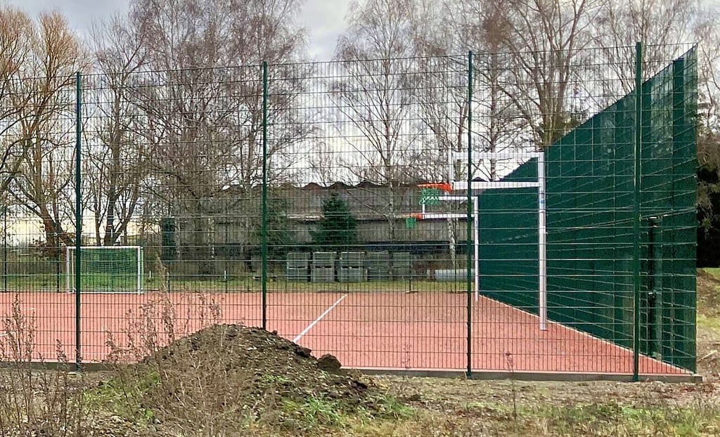 Der Fangzaun ist fertig, sodass der neue Sportplatz eröffnet werden kann.