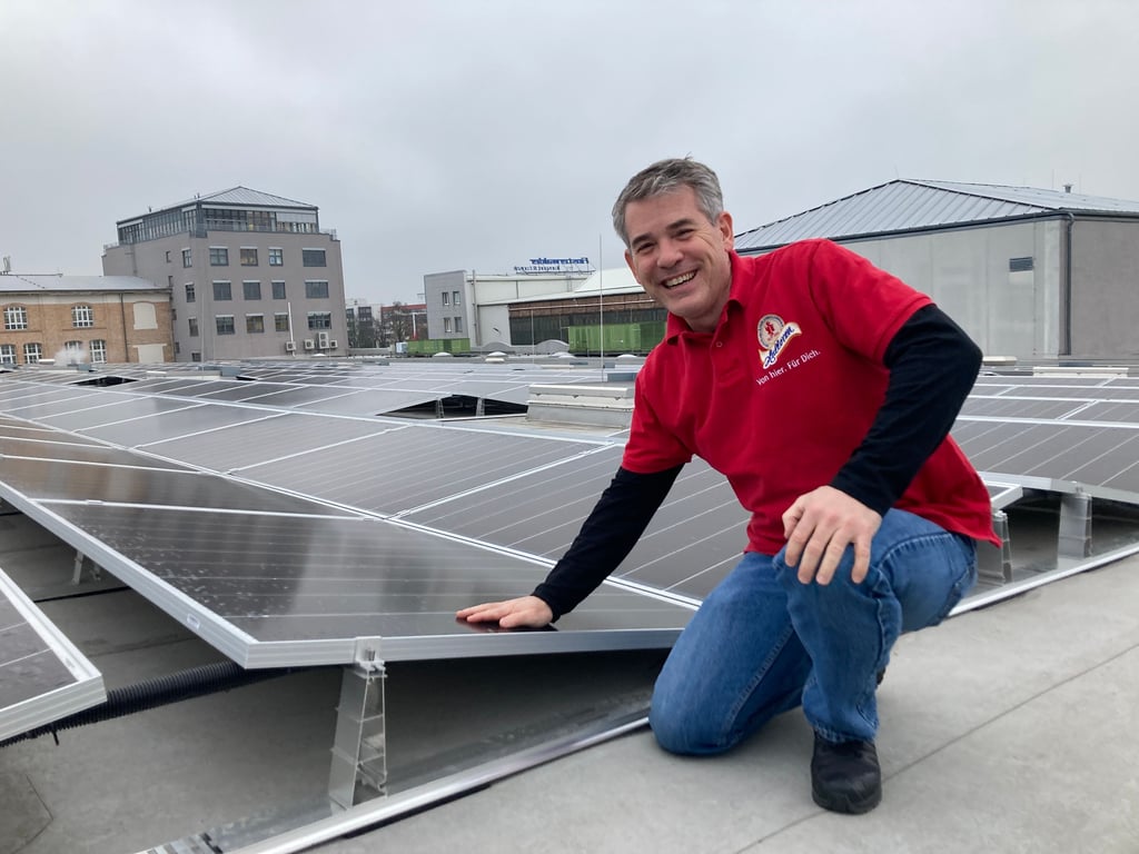 Halloren-Chef Darren Ehlert zeigt die neue Solaranlage auf dem Fabrikdach.
