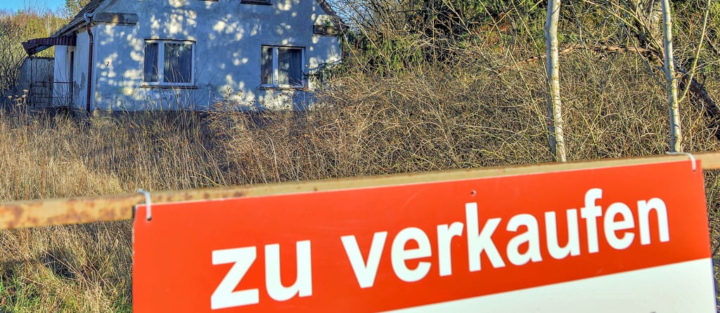 Ein Schild mit der Aufschrift „zu verkaufen“ steht auf einem Grundstück mit einem Einfamilienhaus. Der Verkauf von Immobilien ist im Altmarkkreis unter anderem wegen der gestiegenen Zinsen und der Inflation schwieriger geworden.
