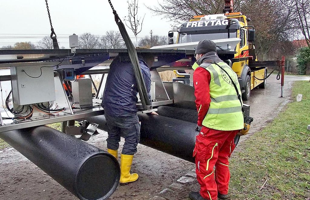 Mit Warnweste und Gummistiefel ausgestattet befestigen die Mitarbeiter der Schwarzwälder Firma EKS-Anlagenbau die Regenerationsanlage im Stadtsee Stendal.