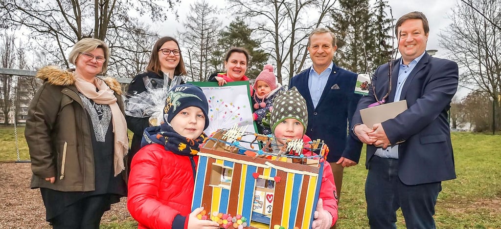 Lennox und Nele aus der integrativen Kita „Haus Sonnenschein“ in Sangerhausen präsentieren ein Modell des Bauwagens. Die 6.000 Euro von Thomas Peckruhn (2. von rechts) sollen in den Forscherwagen fließen.