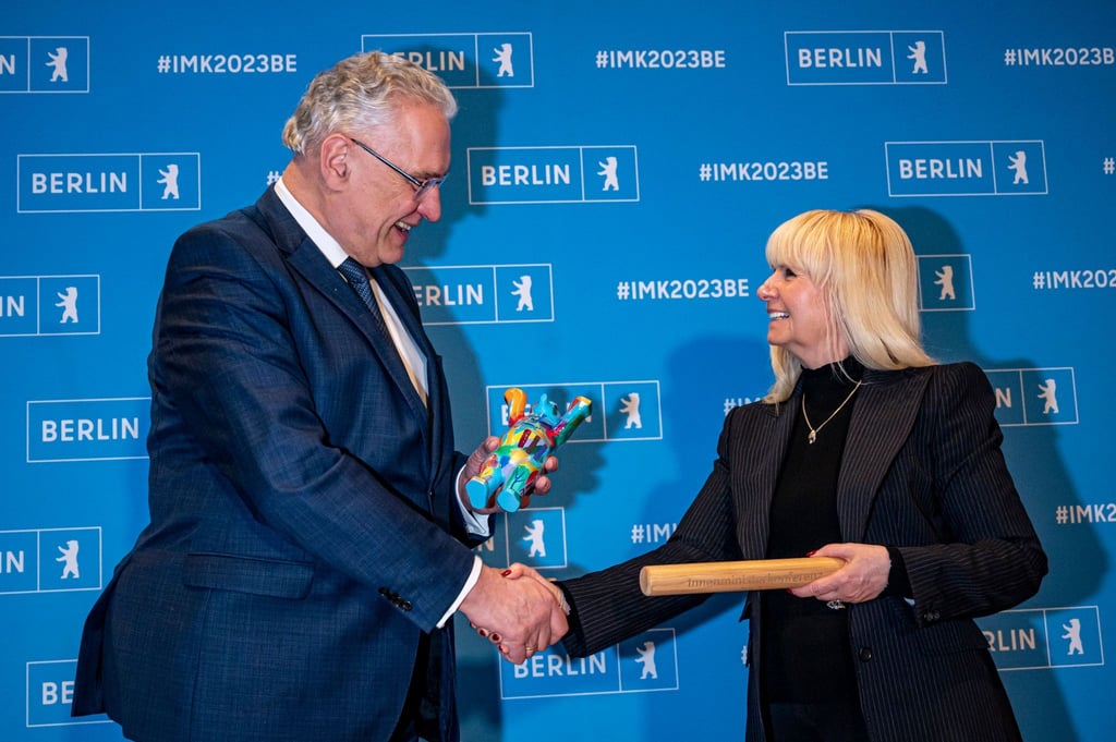 Joachim Herrmann (CSU), Innenminister von Bayern, übergibt den Staffelstab als Symbol für den Vorsitz der Ständigen Konferenz der Innenminister und -senatoren der Länder an Iris Spranger (SPD), Berliner Senatorin für Inneres, Sport und Digitalisierung.