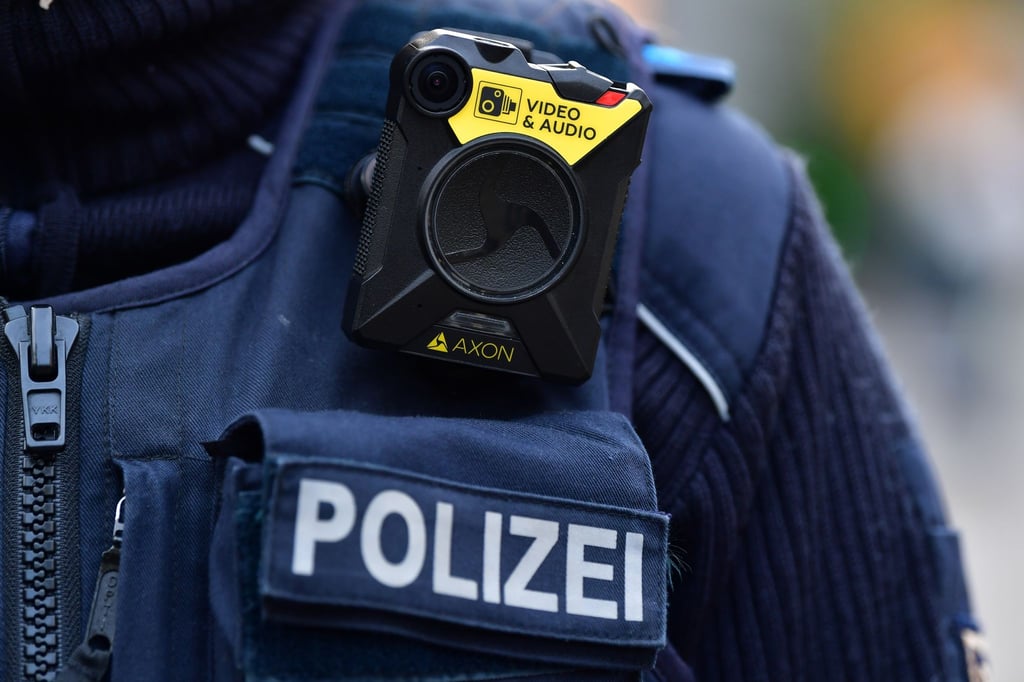 Eine Polizeimeisterin geht während einer Streife mit einer mobilen Körperkamera über einen Weihnachtsmarkt.