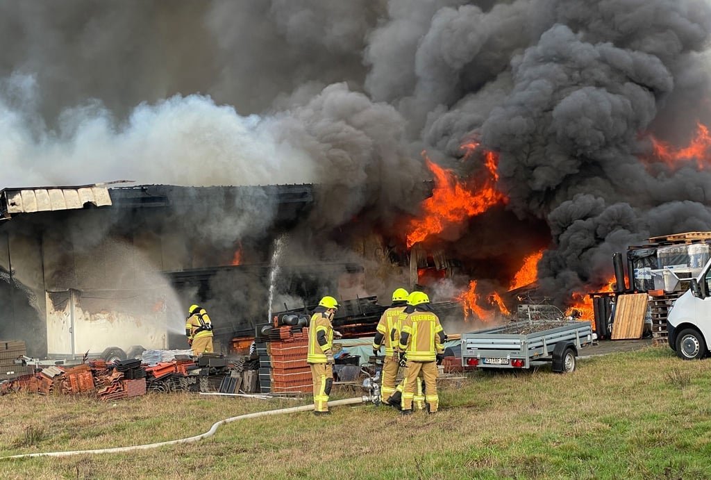 Feuerwehrleute bekämpfen den Brand einer Lagerhalle in Rastede im Kreis Ammerland.