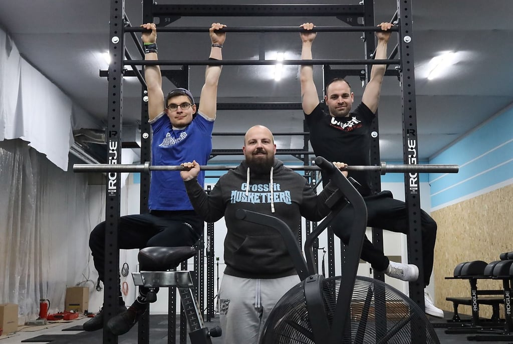Betreiber Christian Thomas (Mitte) baut mithilfe von Trainer Markus Wilhelms (links) und Mitglied Enrico Hermann (rechts) die neue Sporthalle für die „CrossFit Musketeers“ auf. Auch andere Mitglieder engagieren sich für das Projekt.