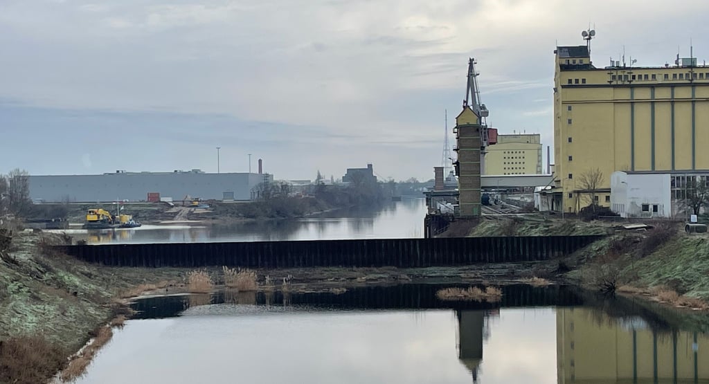 Auf Höhe der Steinkopfinsel ist der Industriehafen (im Foto oben) noch abgetrennt. Der alte Industriehafen soll reaktiviert, wasserstandsunabhängig und an den Magdeburger Hafen angeschlossen werden. Dazu wird ein sogenannter Fangedamm errichtet, wofür bereits die Arbeiten begonnen haben (links).