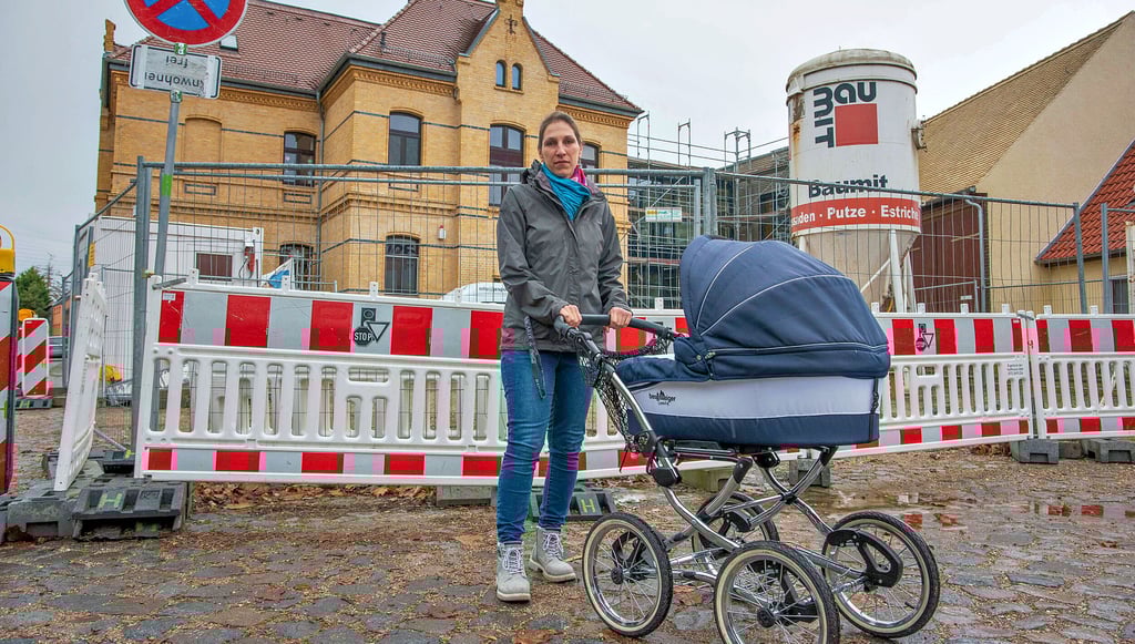 Anni Kaiser mit Söhnchen Colin vor der Kita Luisenkinder, wo noch immer die Bauarbeiter das Sagen haben.