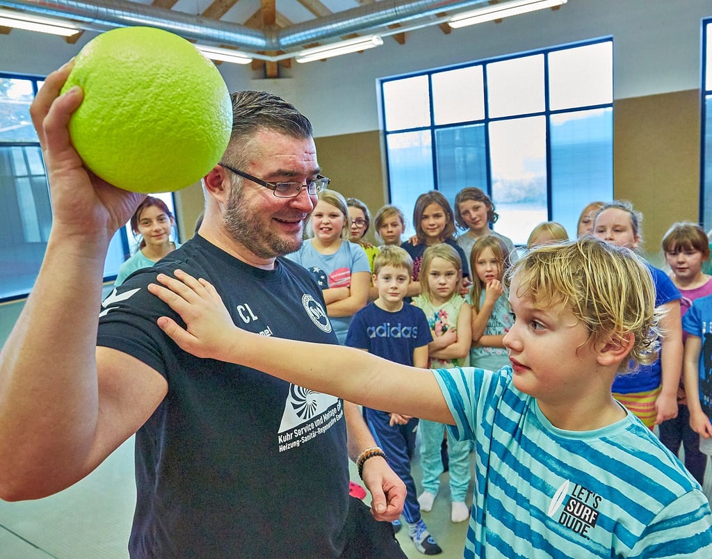 Der siebenjährige Paul übt mit dem Handballtrainer Claus Luther.