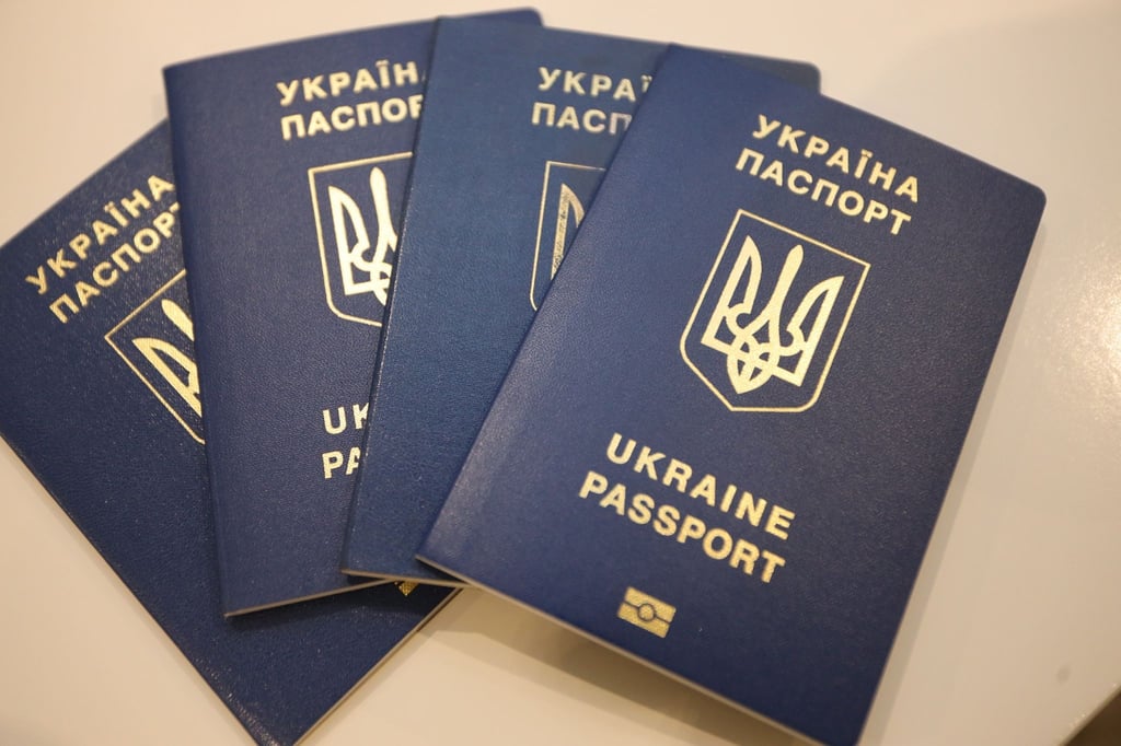 Vier Reisepässe von Geflüchteten aus der Ukraine liegen auf einem Tisch.