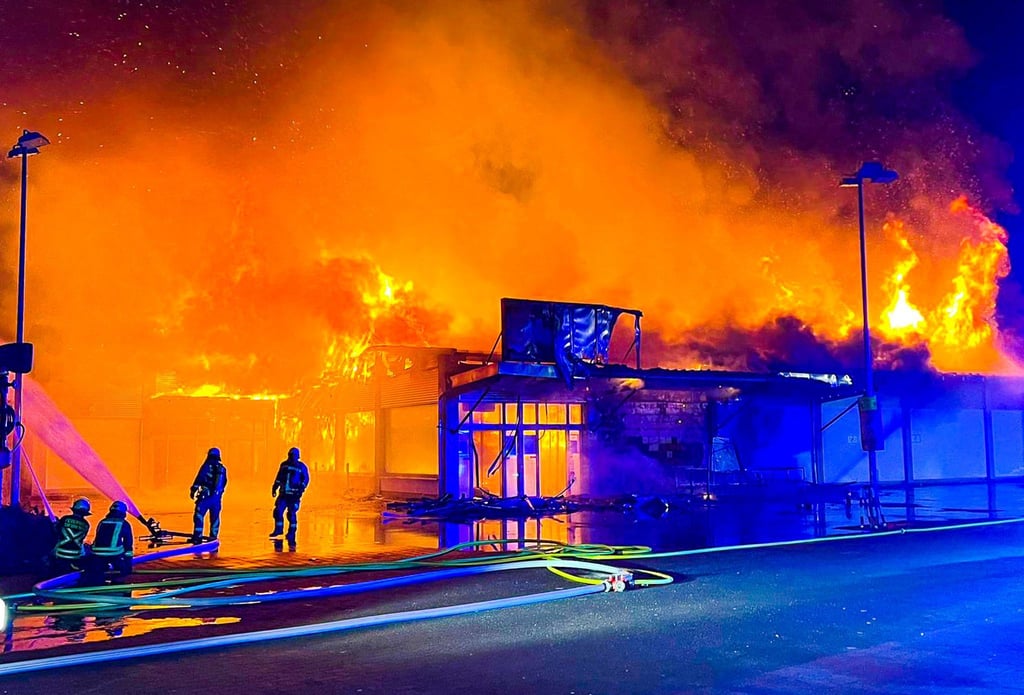 Die Feuerwehr löscht einen brennenden Supermarkt in Bergfelde.