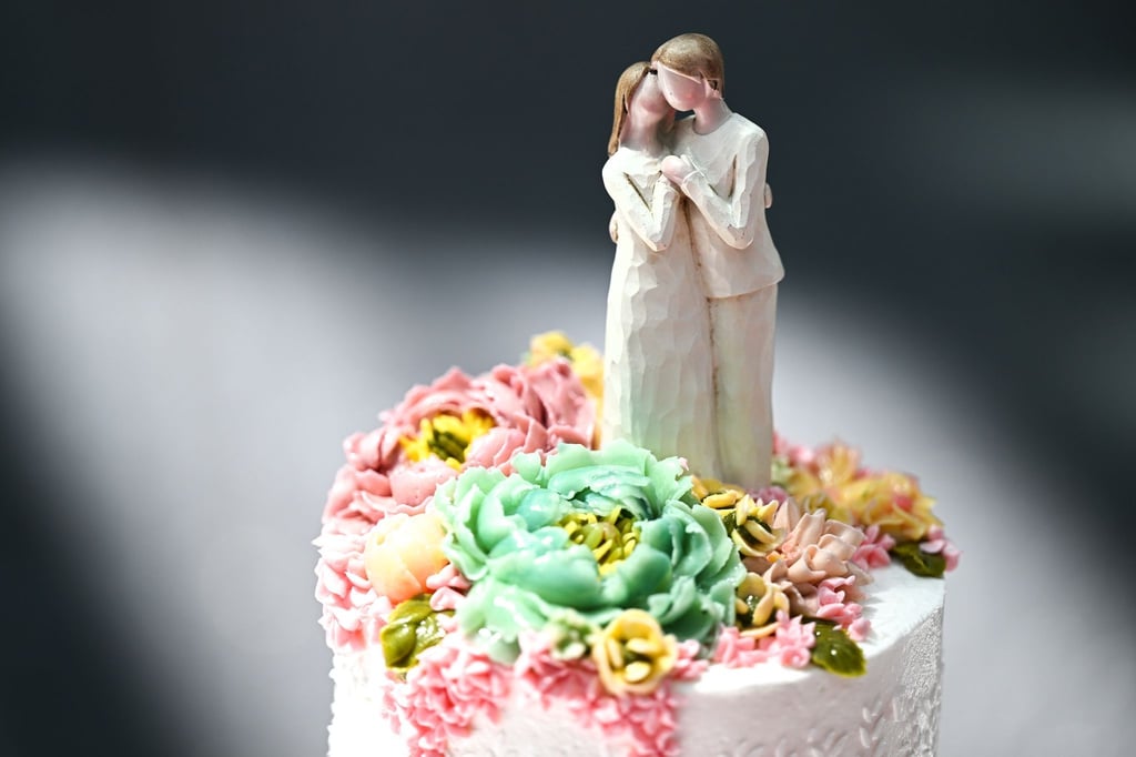 Eine Figur steht auf einer Hochzeitstorte.