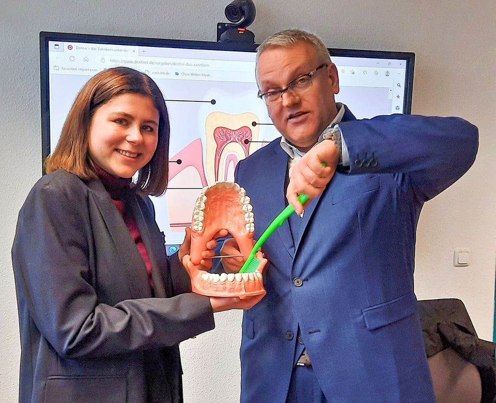 Zahnmedizin-Stipendiatin Emily Marth „übt“ das Zähneputzen mit Landrat Götz Ulrich.