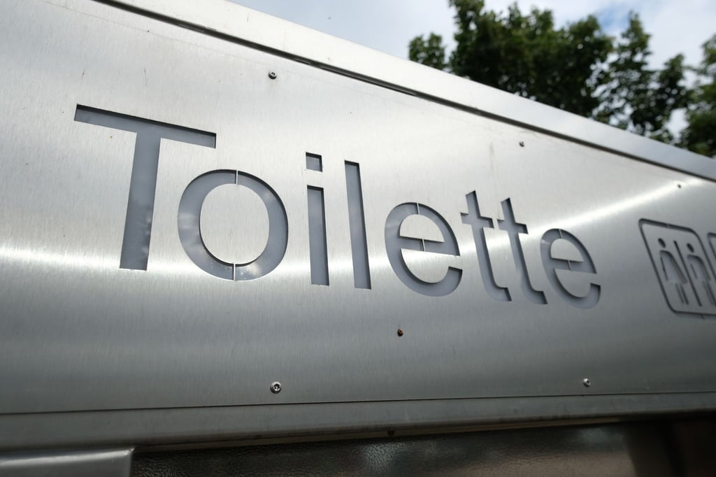 Ein Schild weist den Weg zu einer öffentlichen Toilette.