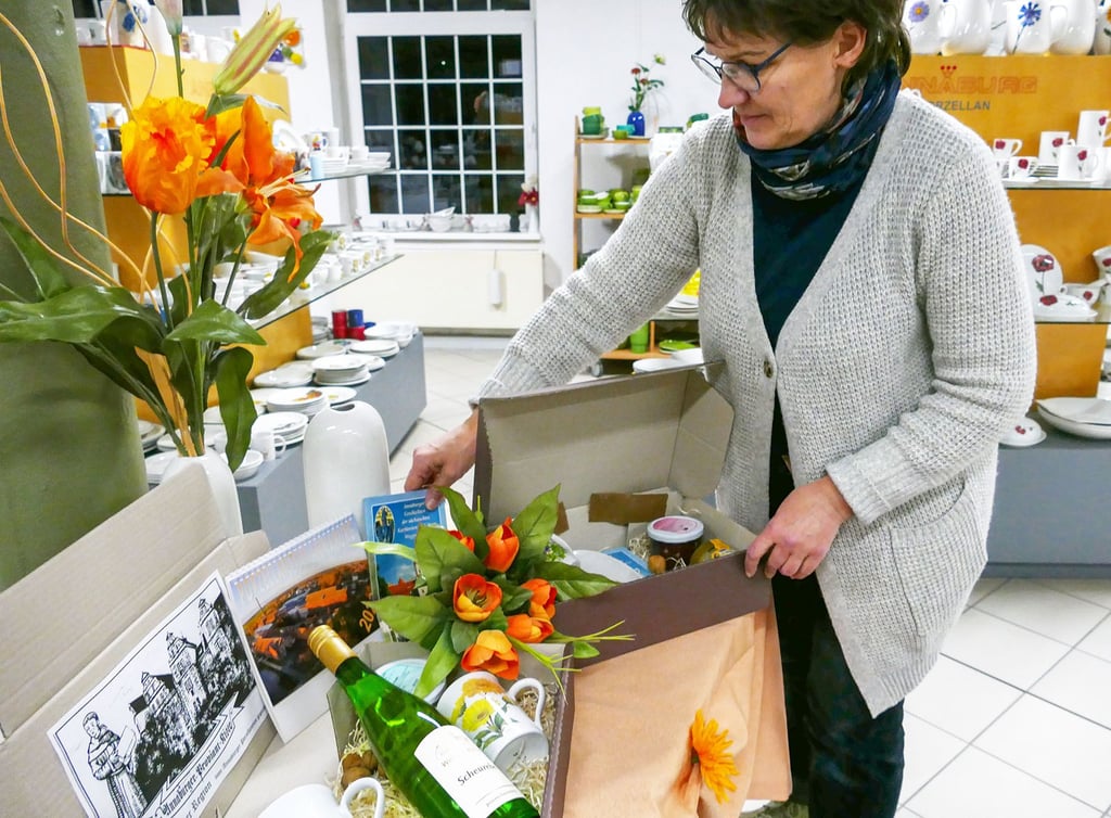 Katrin Greif, Vorstandsmitglied des Fördervereins Annaburger Porzellaneum, zeigt, welche Produktkombinationen es für die Annaburger-Proviant-Kiste gibt.