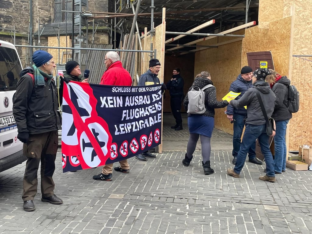 Vor der Stadtratssitzung in der Ulrichskirche haben Bürger gegen die geplante Erweiterung des Flughafens Leipzig/Halle protestiert.