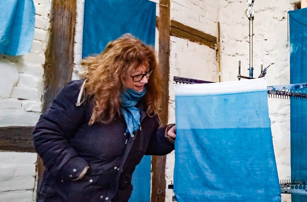 Rosanna Minelli prüft die Blaufärbung einer Stoffbahn, die sie vor wenigen Augenblicken aus dem Färbebad geholt hat.