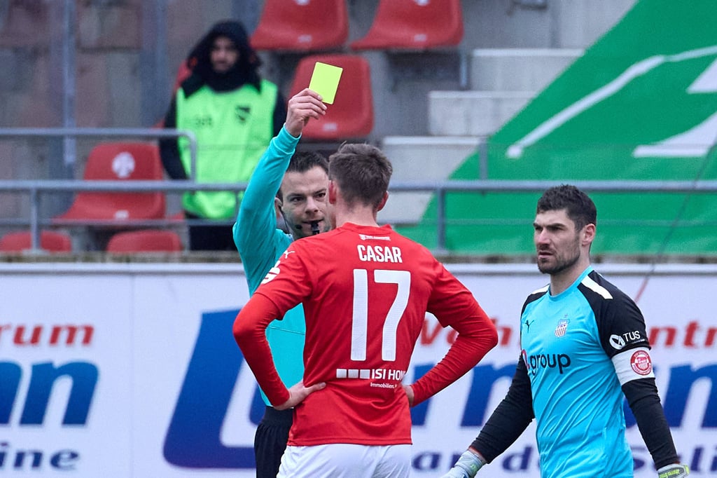 Schiedsrichter Wolfgang Haslberger zeigt Halles Aljaz Casar die Gelbe Karte.