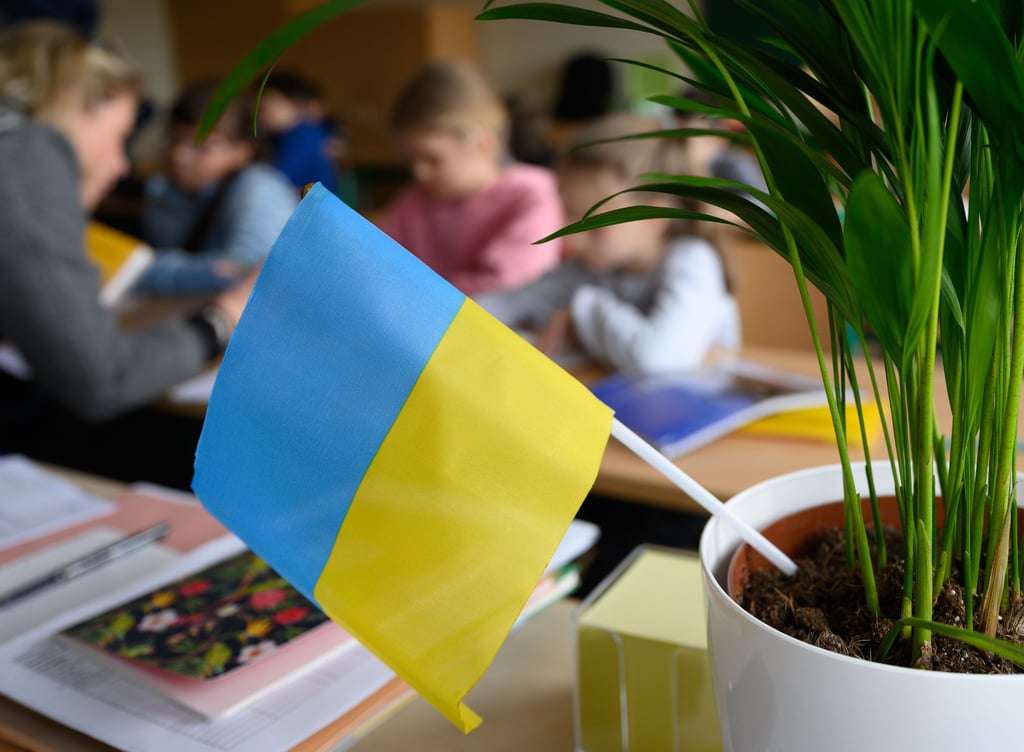 Grundschüler aus der Ukraine sitzen in einem Klassenzimmer.