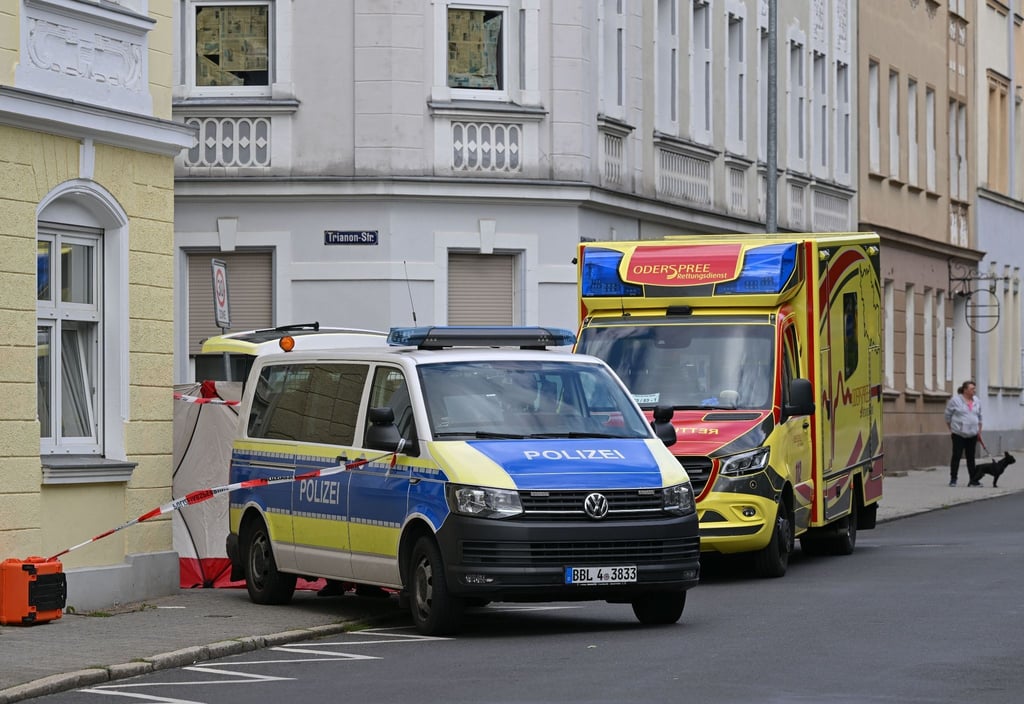 Ein Rettungswagen und ein Einsatzfahrzeug der Polizei stehen am Tatort.