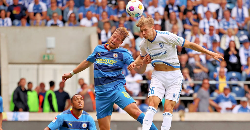 Luca Schuler (r.) vom 1. FC Magdeburg bestreitet als 1,90-Meter-Akteur Luftduelle aussichtsreich und setzte sich hier gegen Eintracht Braunschweigs Verteidiger Brian Behrendt (1,87 Meter) durch.