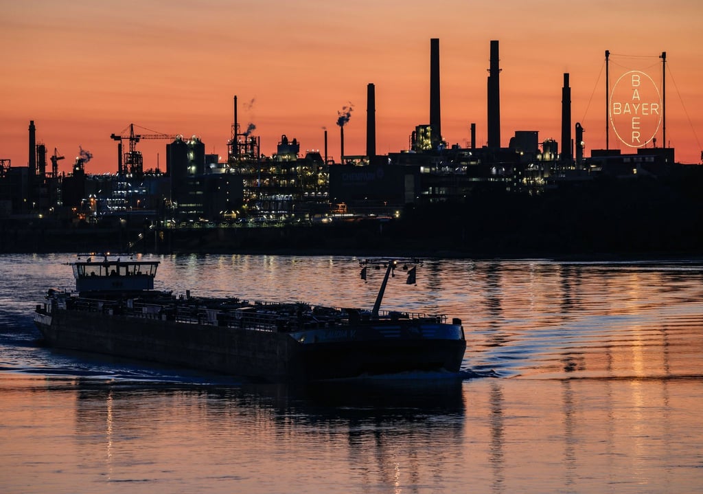 Ein Schiff fährt über den Rhein vor dem Bayer-Werk in Leverkusen. Der Konzern senkt seine Prognose auch für die Pharmasparte.