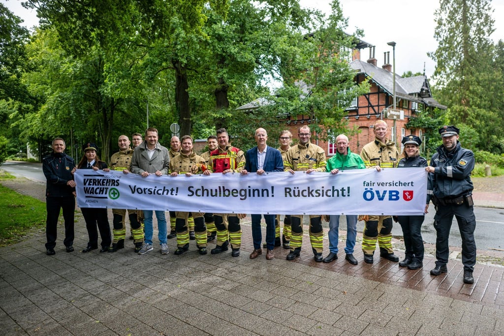 Einsatzkräfte halten ein Banner mit der Aufschrift „Vorsicht! Schulbeginn Rücksicht!“
