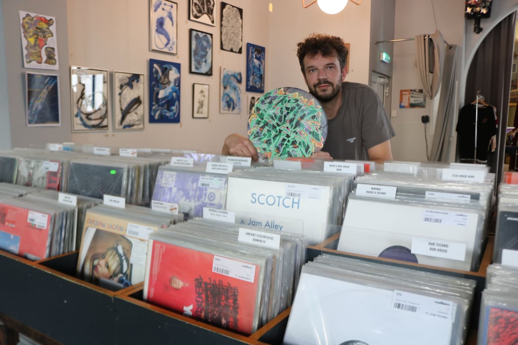 Chris Renard in seinem Magdeburger Plattenladen "Soutunes" mit einer farbig gestalteten Vinyl-Pressung.