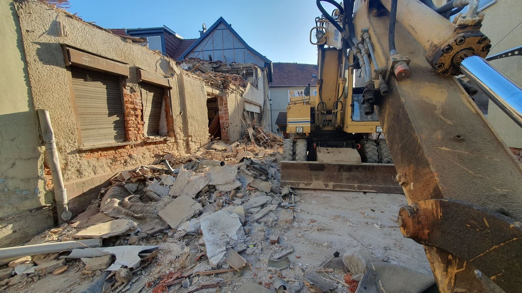Ein Gebäude, das abgerissen wird, steht unmittelbar an der Straße.
